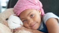 child with cancer hugging teddy bear